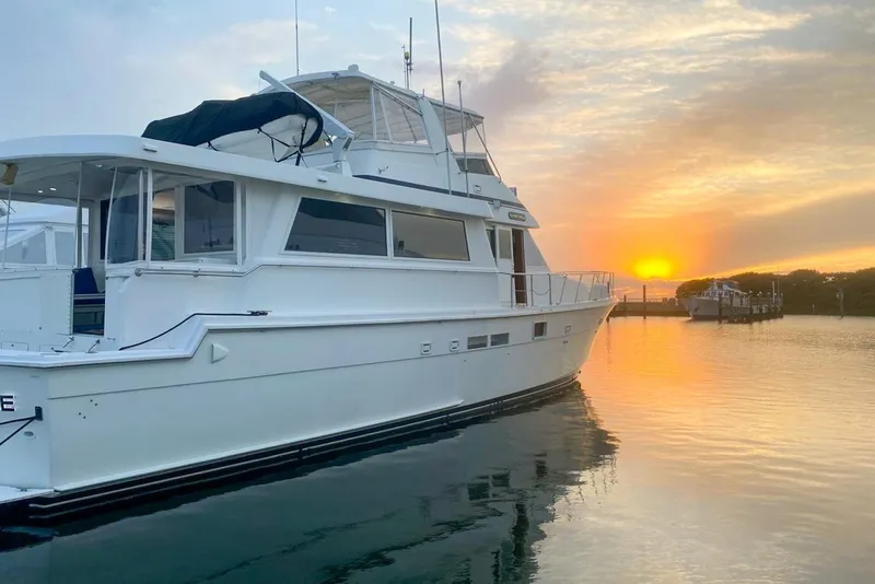 Slide: The Image of 1990 Hatteras 62 Cockpit Motor Yacht at sunset on calm water. - 3