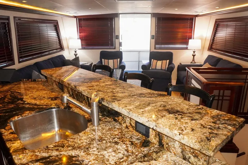 Slide: The Image of Luxurious interior of 1990 Hatteras 62 Cockpit Motor Yacht with granite countertop and cozy seating. - 33