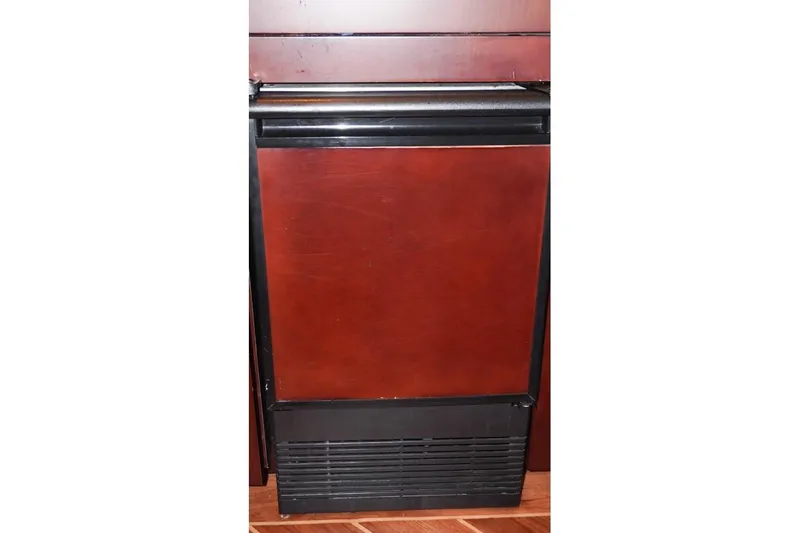 Slide: The Image of Built-in refrigerator on 1990 Hatteras 62 Cockpit Motor Yacht, featuring wood paneling. - 36