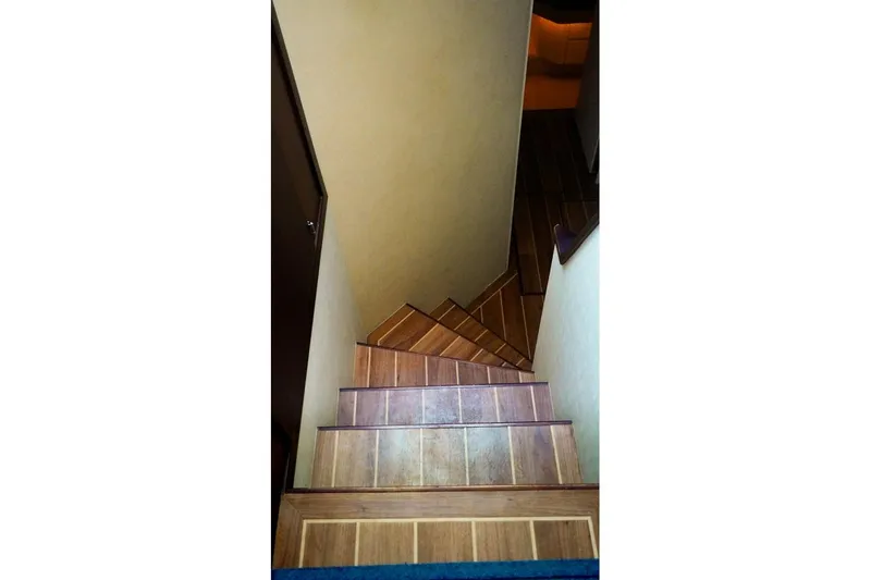Slide: The Image of Wooden staircase inside 1990 Hatteras 62 Cockpit Motor Yacht, leading to lower deck. - 42