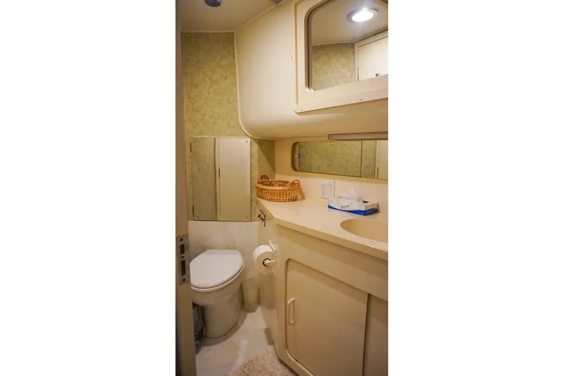 Slide: The Image of Bathroom interior of 1990 Hatteras 62 Cockpit Motor Yacht, featuring sink and toilet. - 44