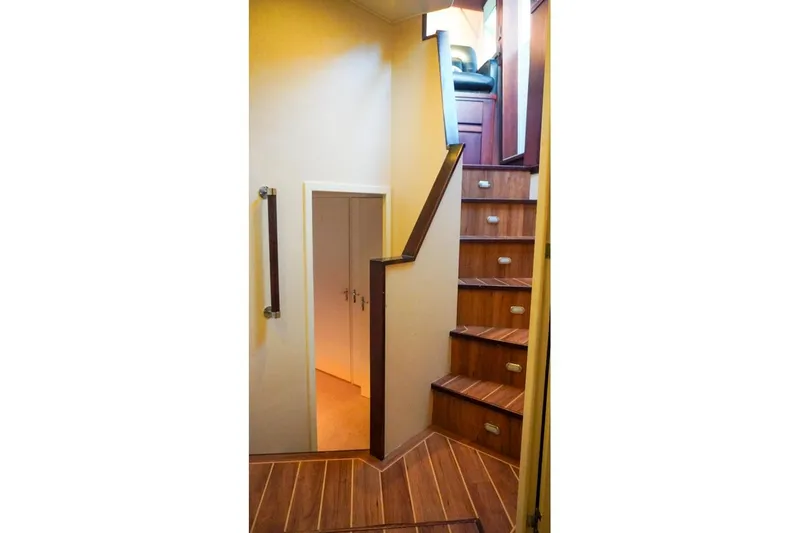 Slide: The Image of Interior staircase of 1990 Hatteras 62 Cockpit Motor Yacht with wooden steps and handrail. - 50