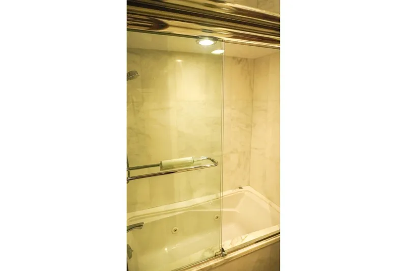 Slide: The Image of Luxurious bathroom with glass-enclosed shower in 1990 Hatteras 62 Cockpit Motor Yacht. - 52