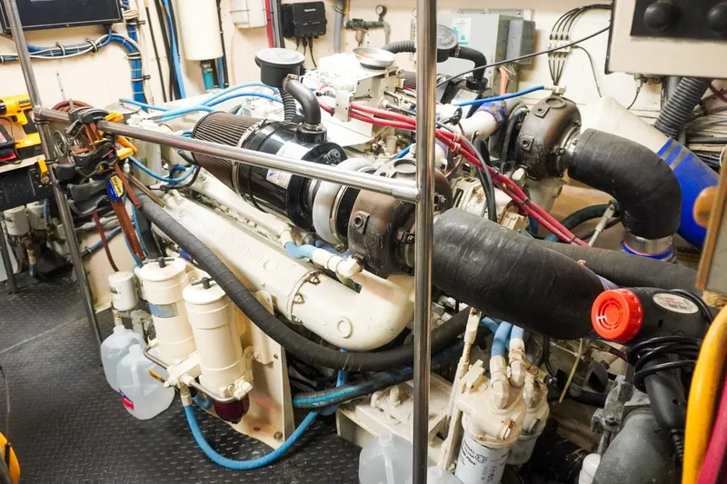 Slide: The Image of Engine room of 1990 Hatteras 62 Cockpit Motor Yacht, showcasing complex machinery and components. - 59