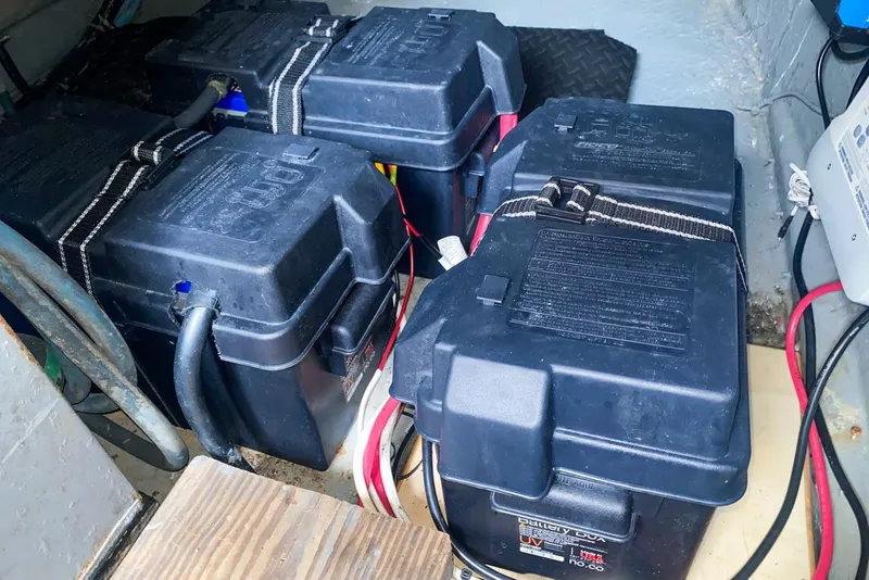 Slide: The Image of Battery compartment of 1990 Hatteras 62 Cockpit Motor Yacht, featuring secured battery boxes. - 67
