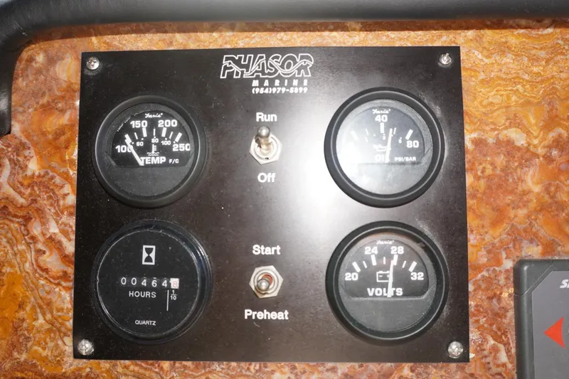 Slide: The Image of Control panel of a 1990 Hatteras 62 Cockpit Motor Yacht with gauges and switches. - 73