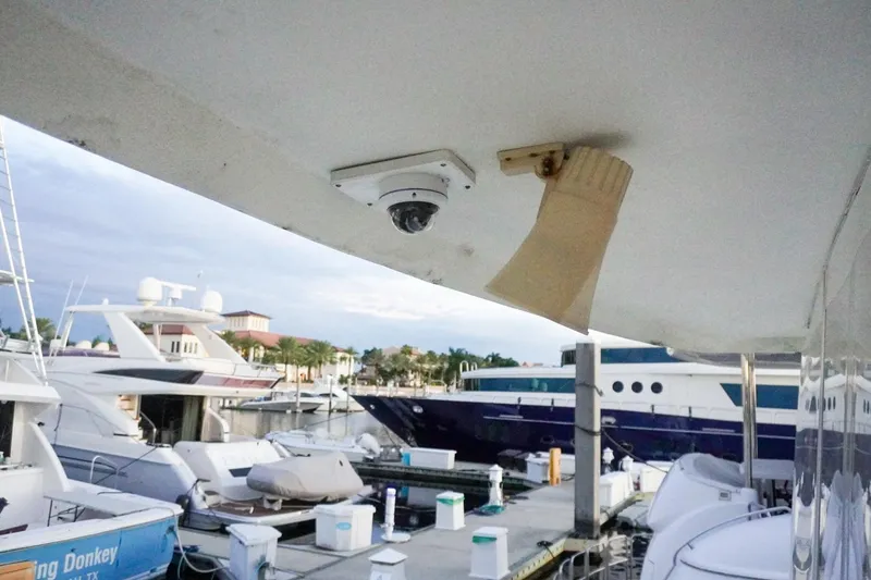 Slide: The Image of 1990 Hatteras 62 Cockpit Motor Yacht docked at marina with security camera. - 80