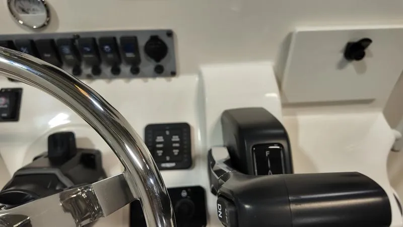 Slide: The Image of Control panel of 2025 Sea Born FX 21 BAY boat with steering wheel and switches. - 14