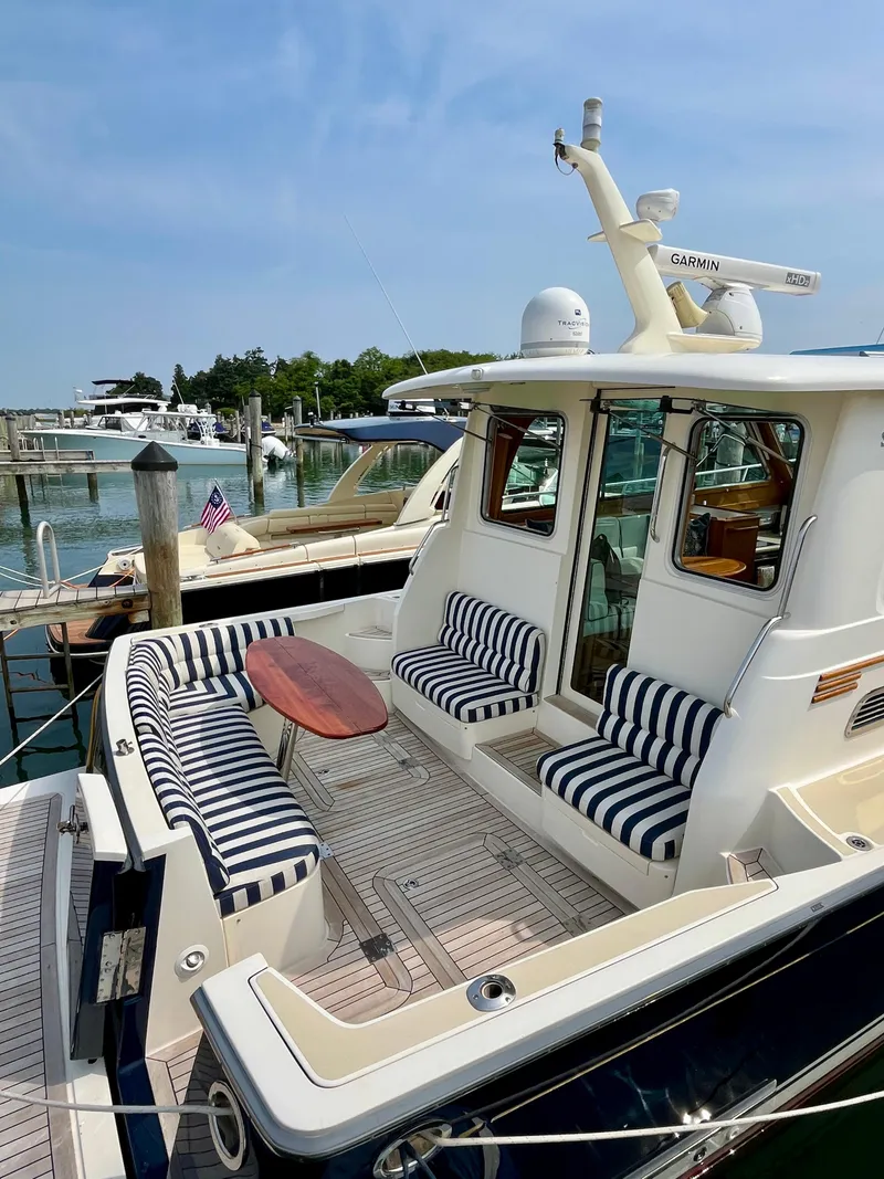 Slide: The Image of 2010 Sabre 40 Sedan yacht with striped seating, docked at a marina. - 10