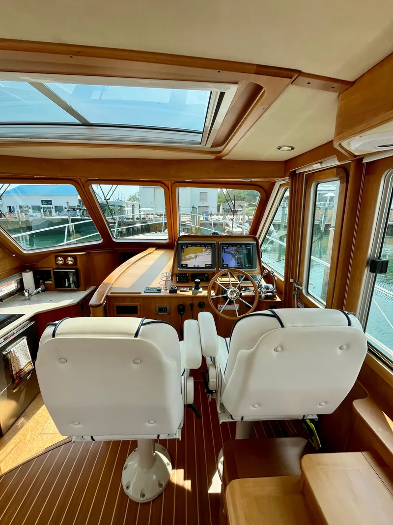 Slide: The Image of Interior of 2010 Sabre 40 Sedan yacht with helm, navigation screens, and white captain chairs. - 20