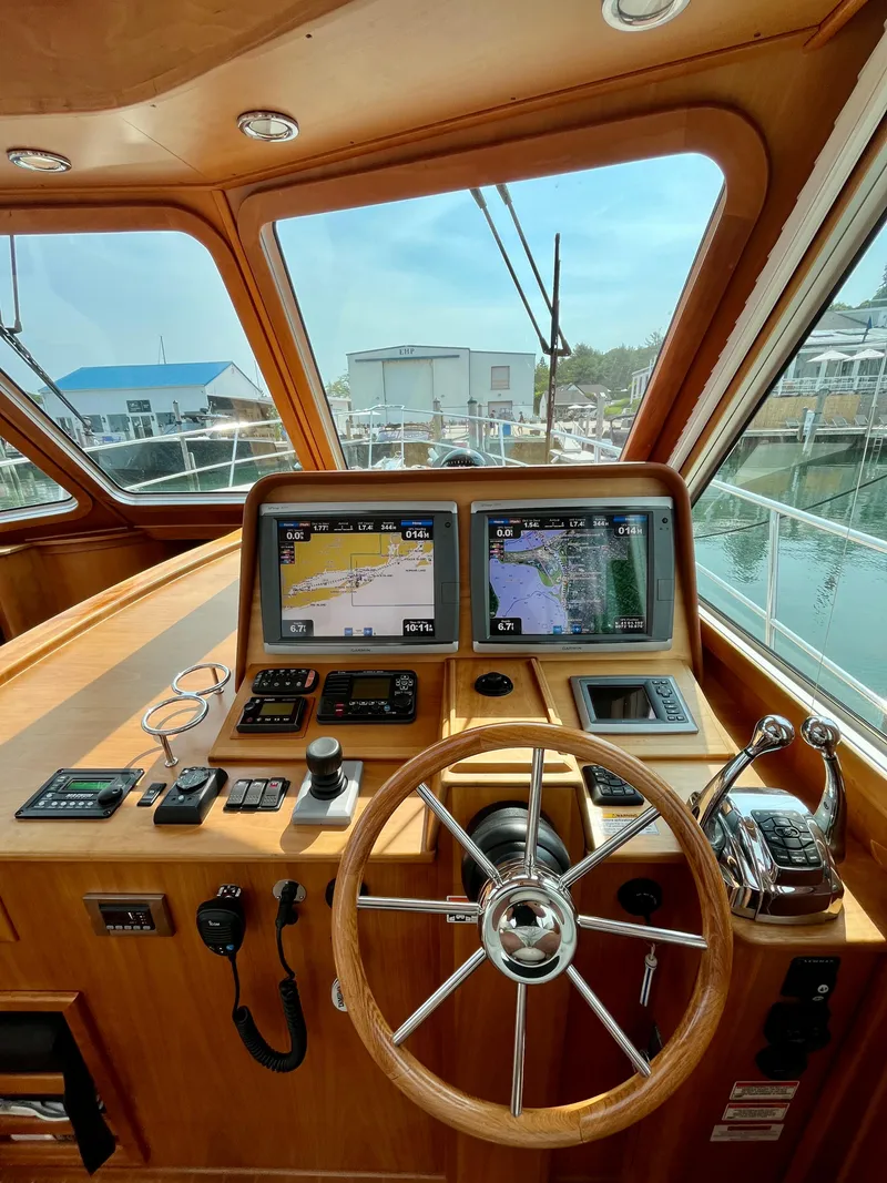Slide: The Image of 2010 Sabre 40 Sedan helm with navigation screens and wooden steering wheel. - 22
