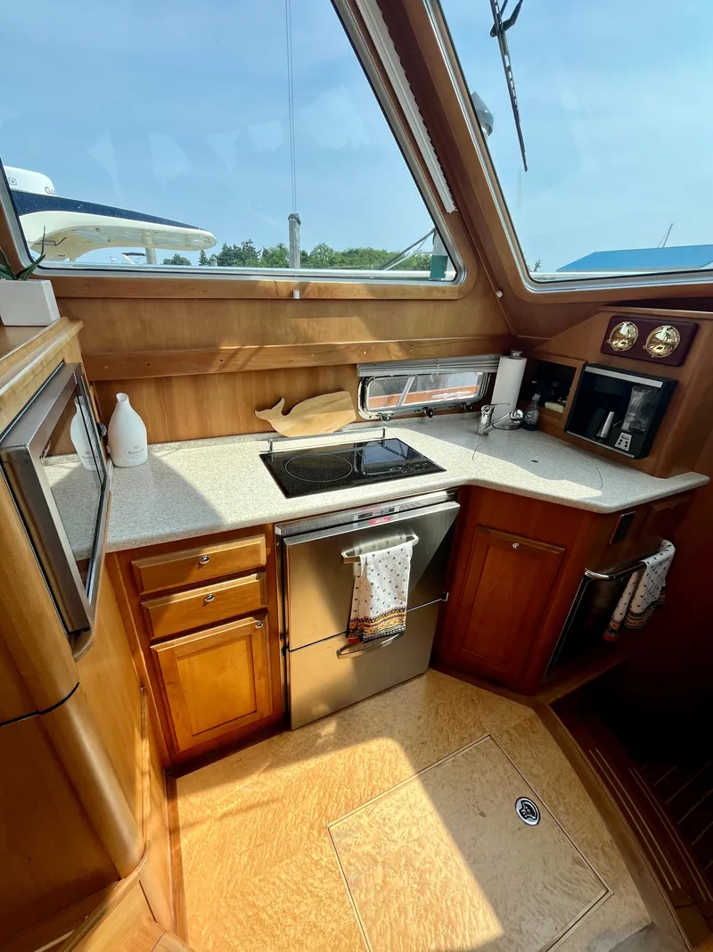Slide: The Image of 2010 Sabre 40 Sedan yacht kitchen with wooden cabinetry and modern appliances. - 24