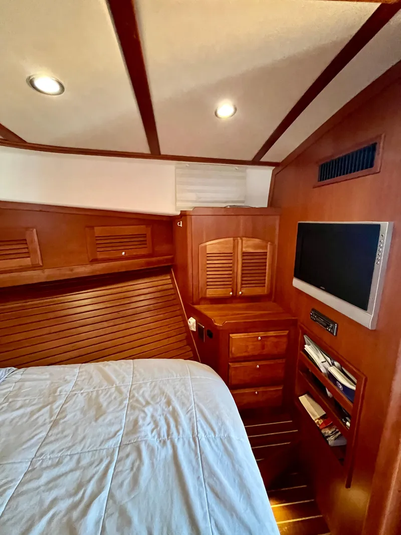 Slide: The Image of Interior of 2010 Sabre 40 Sedan with wood paneling, bed, and mounted TV. - 32