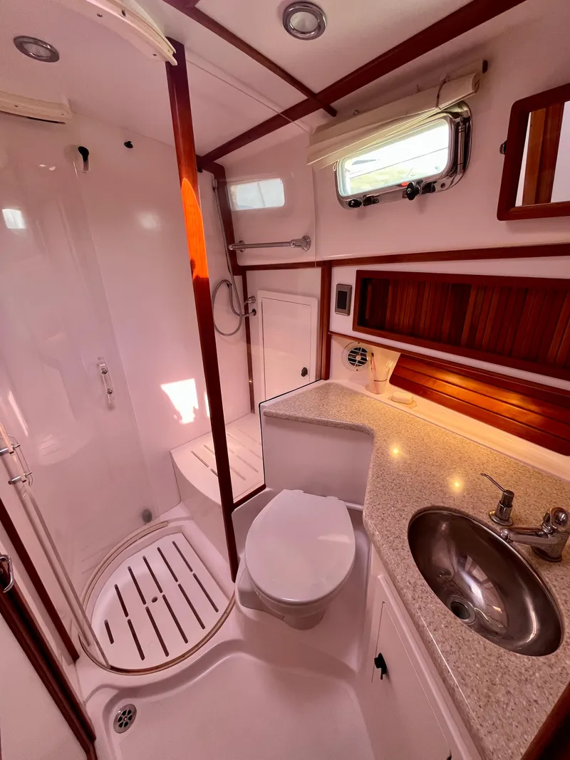 Slide: The Image of 2010 Sabre 40 Sedan yacht bathroom with shower, sink, and wooden accents. - 33