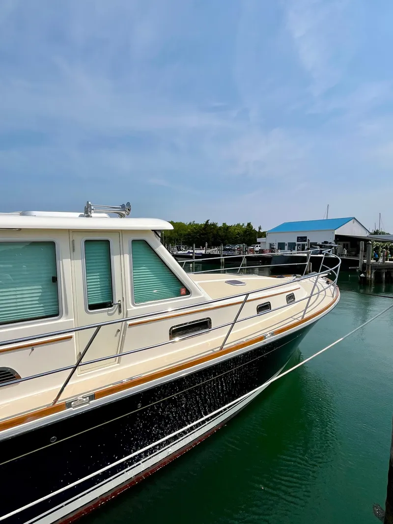 Slide: The Image of 2010 Sabre 40 Sedan yacht docked in a marina under a clear blue sky. - 45