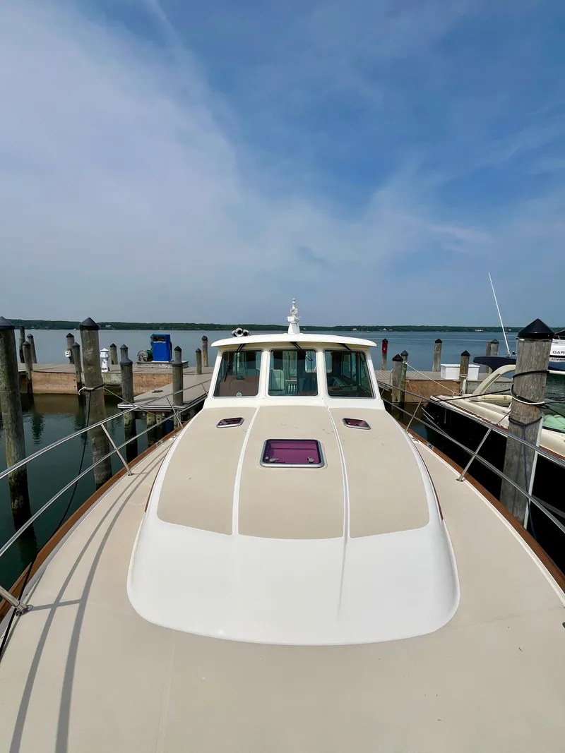 Slide: The Image of 2010 Sabre 40 Sedan yacht docked at a marina under a clear blue sky. - 46