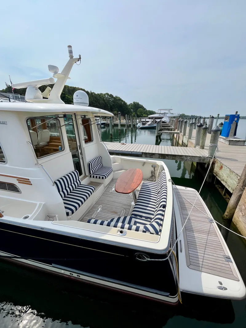 Slide: The Image of 2010 Sabre 40 Sedan yacht docked with striped seating and wooden table. - 9