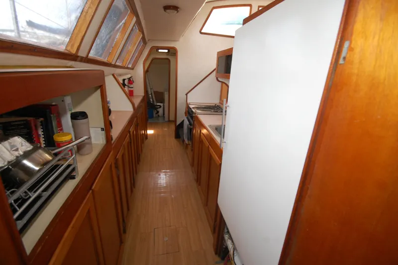 Slide: The Image of Interior of 2003 Leopard Morrelli & Melvin Catamaran with wooden cabinetry and galley kitchen. - 11