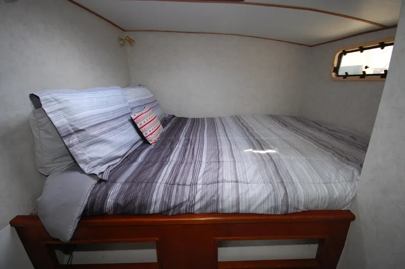 Slide: The Image of Cozy bedroom in 2003 Leopard Morrelli & Melvin Catamaran with striped bedding and small window. - 8