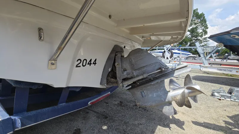Slide: The Image of 2007 Crownline 220EX boat stern with propeller and trailer, parked outdoors. - 12