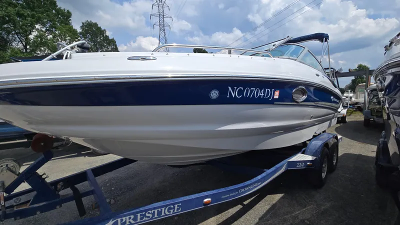 Slide: The Image of 2007 Crownline 220EX boat on trailer, blue and white, parked outdoors. - 3