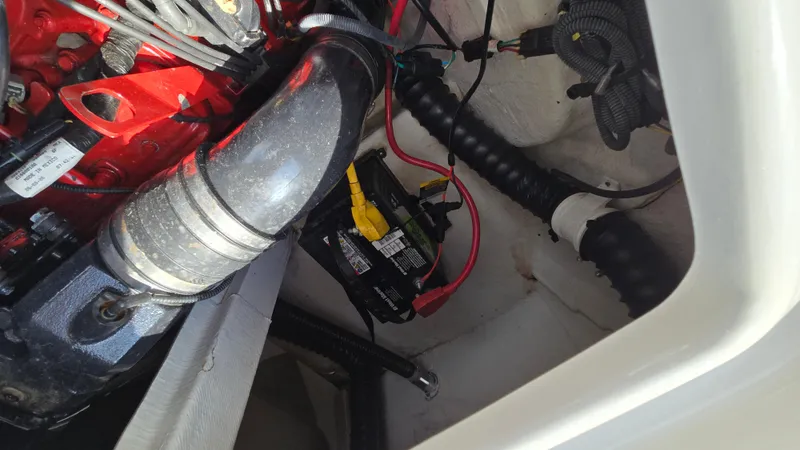Slide: The Image of Engine compartment of a 2007 Crownline 220EX boat, showing battery and wiring. - 48