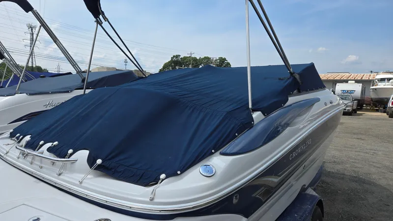 Slide: The Image of 2007 Crownline 220EX boat with blue cover, parked outdoors on a sunny day. - 9