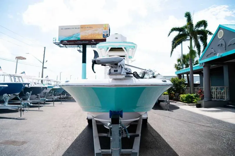 Slide: The Image of 2024 Caymas 281 HB boat on trailer, displayed outdoors with palm trees and clear sky. - 2