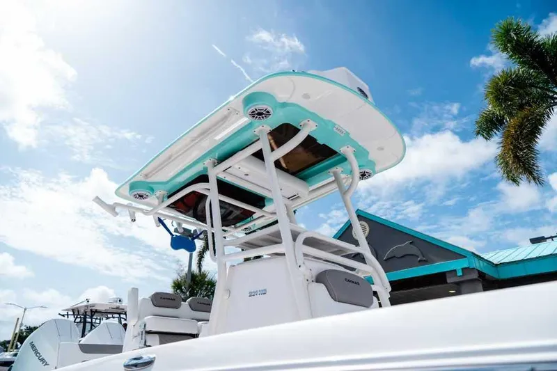 Slide: The Image of 2024 Caymas 281 HB boat with T-top, under clear blue sky, palm tree nearby. - 3