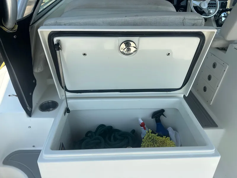 Slide: The Image of Open storage compartment on 2006 Hydra-Sports Vector 2900 VX boat with cleaning supplies and rope. - 19