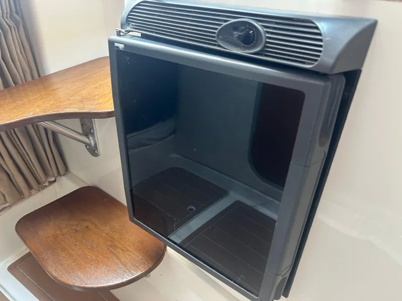 Slide: The Image of 2006 Hydra-Sports Vector 2900 VX cabin interior with compact refrigerator and wooden shelves. - 32