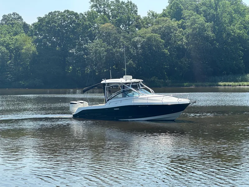 Slide: The Image of 2006 Hydra-Sports Vector 2900 VX boat cruising on a calm lake with forested background. - 6