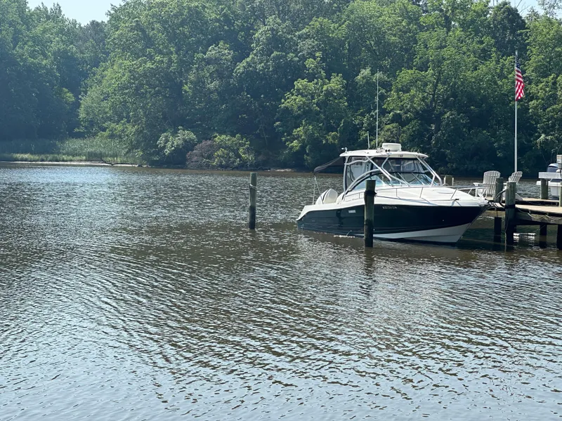Slide: The Image of 2006 Hydra-Sports Vector 2900 VX boat docked on a serene lake with lush greenery. - 9