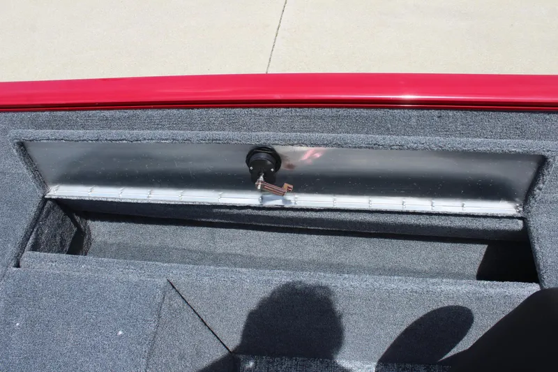 Slide: The Image of 2025 Tracker Pro Guide V-175 Combo boat storage compartment with red trim and gray interior. - 23