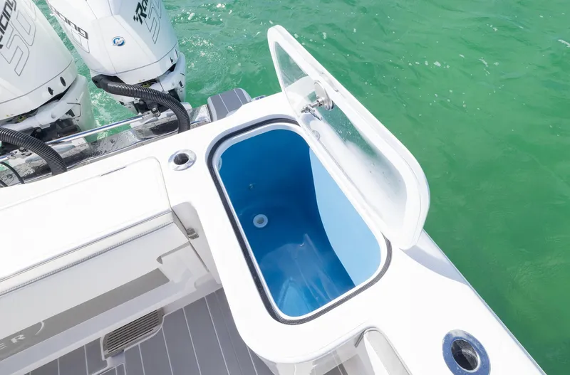 Slide: The Image of Open livewell on 2025 Blackwater 43 Sportfish boat, with twin outboard engines in turquoise water. - 33