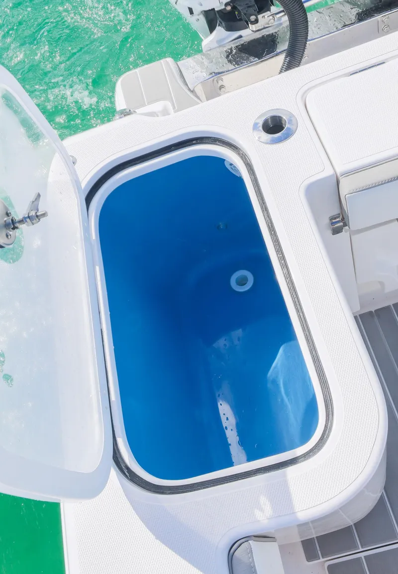Slide: The Image of Livewell on 2025 Blackwater 43 Sportfish boat, open lid, blue interior, ocean background. - 34