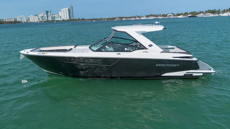 Slide: The Image of 2018 Monterey 378 Super Express boat on water with city skyline in background. - 2