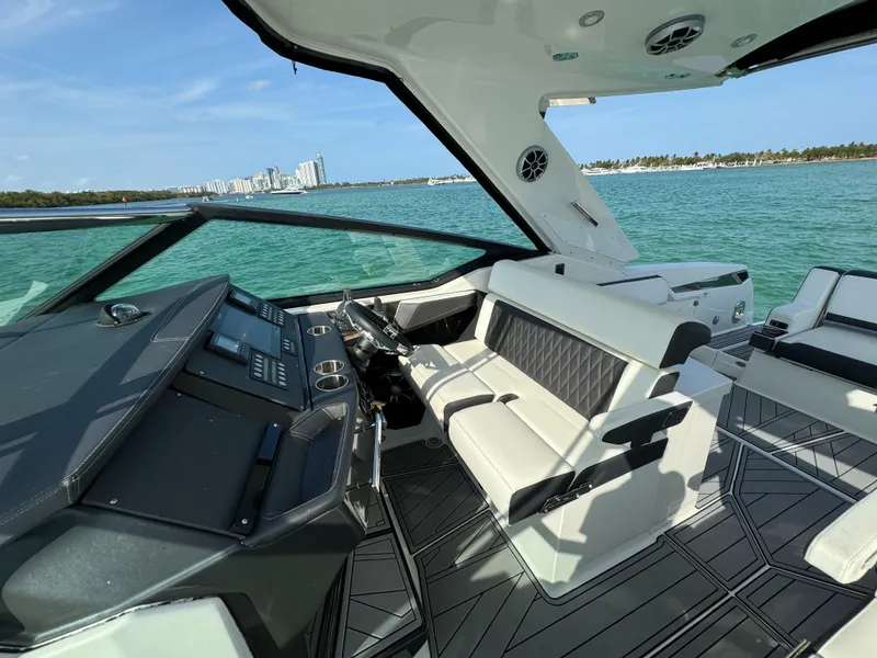 Slide: The Image of 2018 Monterey 378 Super Express yacht interior with modern dashboard and seating, overlooking ocean. - 13