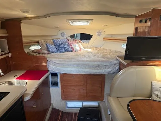 Slide: The Image of 2003 Rinker Fiesta Vee 342 interior with cozy bed, kitchenette, and seating area. - 15