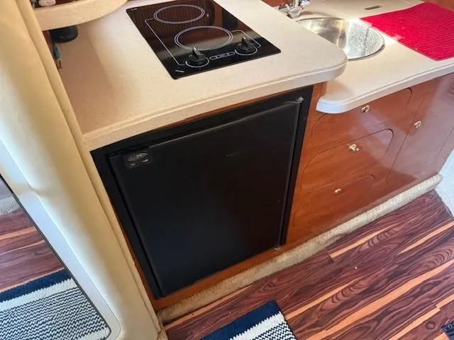 Slide: The Image of 2003 Rinker Fiesta Vee 342 kitchen area with stove, sink, and refrigerator. - 17