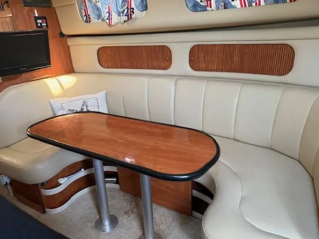 Slide: The Image of 2003 Rinker Fiesta Vee 342 interior with beige seating and wooden table. - 18