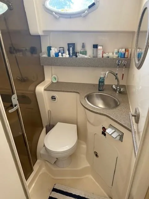 Slide: The Image of 2003 Rinker Fiesta Vee 342 bathroom with sink, toilet, and toiletries on shelf. - 19