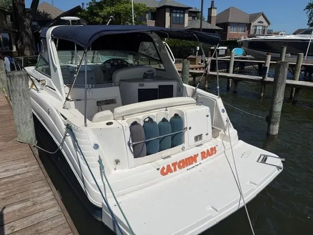 Slide: The Image of 2003 Rinker Fiesta Vee 342 boat docked, featuring a spacious deck and navy canopy. - 3