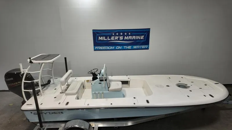 Slide: The Image of 2025 Spyder FX19 Vapor boat displayed indoors at Miller's Marine dealership. - 1