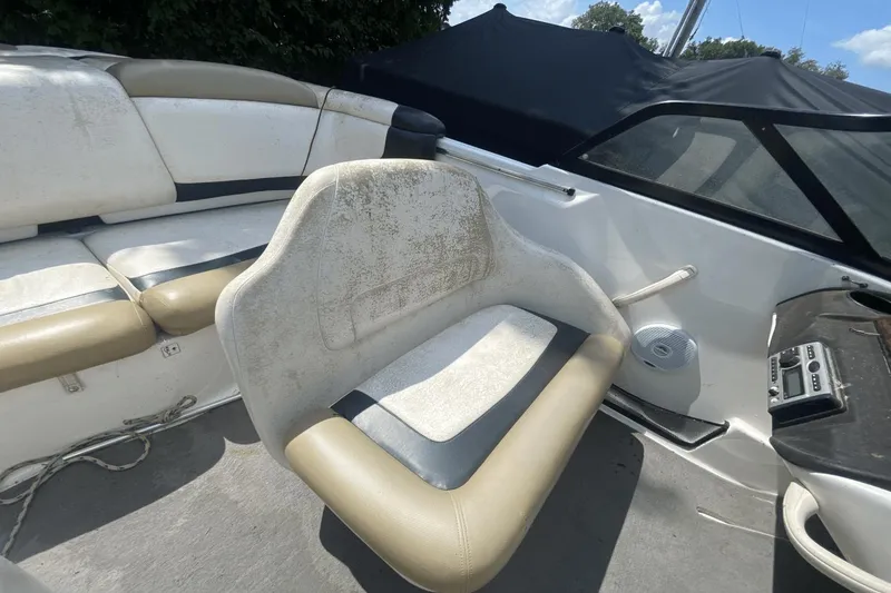 Slide: The Image of 2005 Sea-Doo Utopia 185 boat interior with beige and white seating, steering console, and speaker. - 10