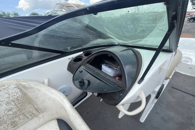 Slide: The Image of 2005 Sea-Doo Utopia 185 boat dashboard with open glove compartment and windshield. - 16