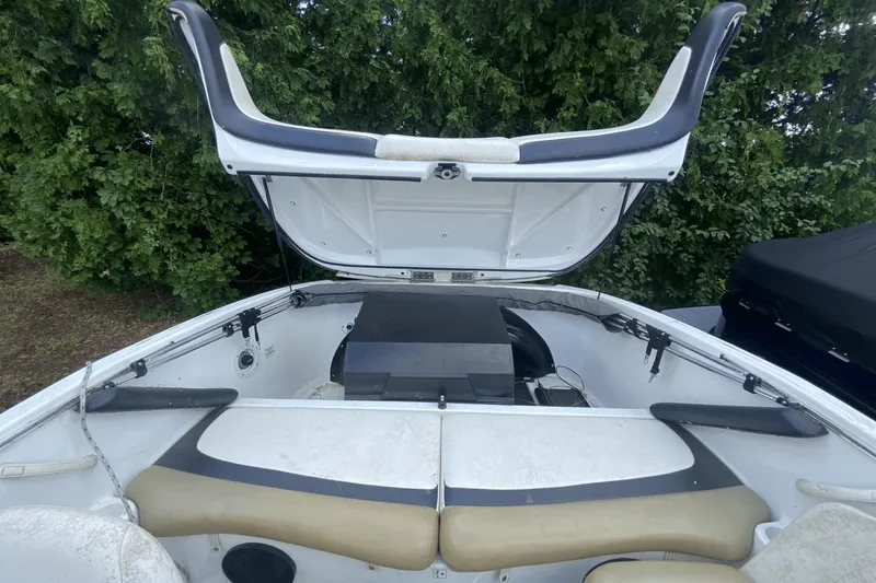 Slide: The Image of 2005 Sea-Doo Utopia 185 boat interior with open engine compartment, surrounded by greenery. - 21