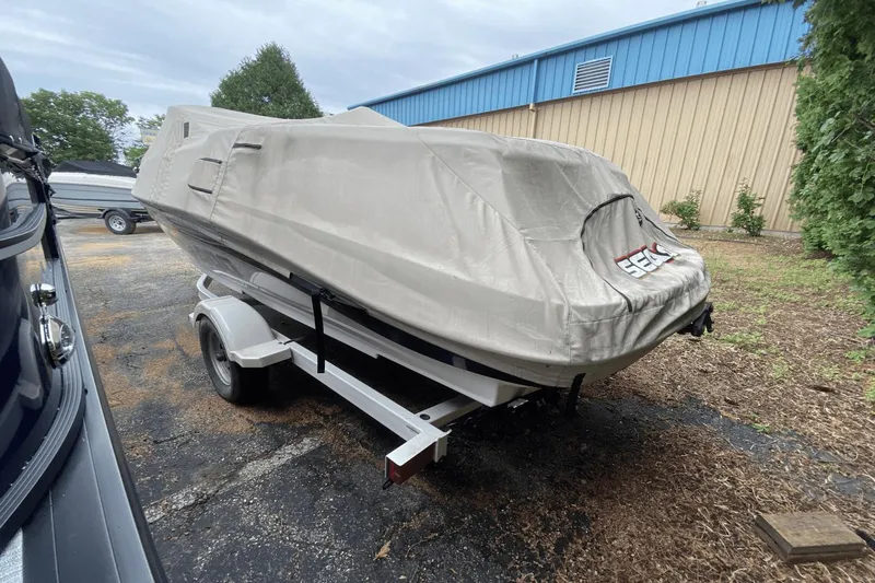 Slide: The Image of 2005 Sea-Doo Utopia 185 boat covered on trailer, parked outdoors. - 26