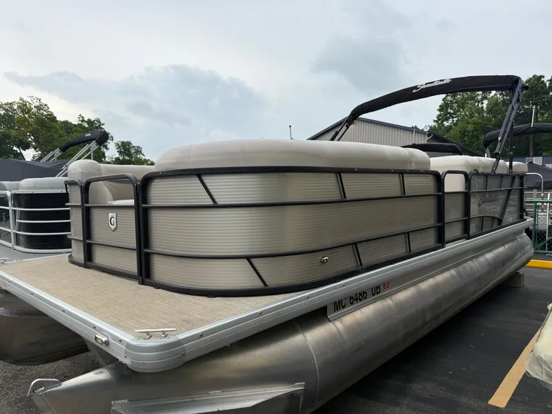 The Image of 2017 Sweetwater 22 pontoon boat with beige seating and black railings, docked outdoors. - 0