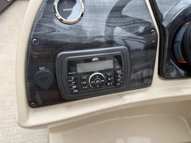 Slide: The Image of Dashboard of a 2017 Sweetwater 22 boat with audio controls and Honda gauge. - 13